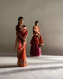 Medhavi Chettri in red silk saree for Mimamsaa campaign, standing in a sunlit studio with another model in the background 
