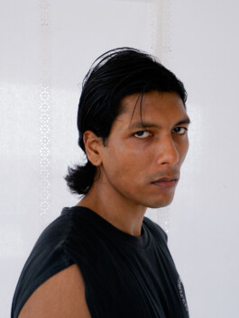 Color side profile of model Gaurav Gharu wearing a sleeveless black T-shirt against a white background 