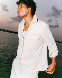 Model Gaurav Gharu in a white outfit near water at sunset during a test photoshoot 