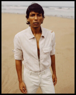 ALF model Gaurav Gharu wearing a light ivory corduroy zip-up shirt and trousers on a beach during editorial shoot 