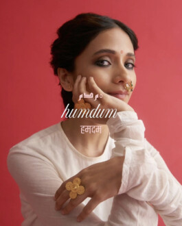 Anushree Vaze wearing statement gold rings and nose pin for Olio’s Humdum jewelry campaign against a red background 