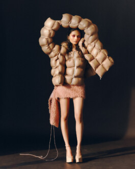 Anushree Vaze wearing an oversized nude puffer jacket and blush mini skirt with platform heels for Dirty Magazine 
