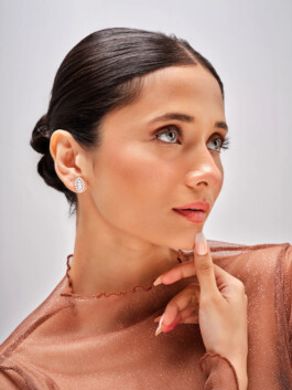 Model Anushree Vaze from ALF modeling agency wearing elegant diamond earrings for the Manara Jewelry campaign, styled with a sheer brown top and polished hair bun. 