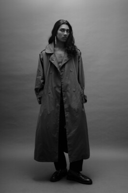 Model Savio Fedrick in a black trench coat, shot in black and white for an ALF editorial by Ambika Singh 