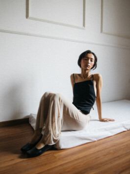 Model Tenzin Martha seated on a mattress in black camisole and cream trousers during editorial shoot for ALF modeling agency India 