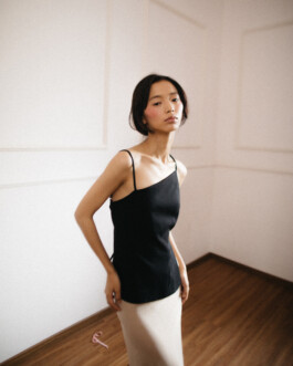 Tenzin Martha poses in black camisole and cream skirt against minimalist wall at ALF model shoot 
