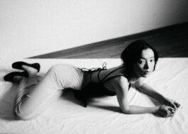 Tenzin Martha in a black-and-white editorial image lying on a white sheet, photographed by Sameer Khatri for A Little Fly modeling agency 
