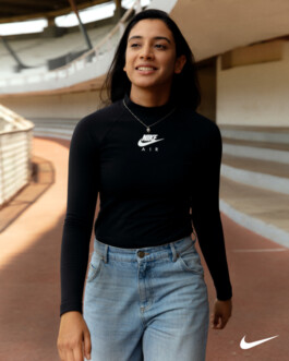 Smiling and walking on a stadium track in Nike Air top and jeans, photographed by Dhruvin Shah for Nike campaign 