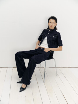 Ngawang Jinpa wearing a black denim co-ord set and pointed heels, sitting on a chair for Pai Models editorial 