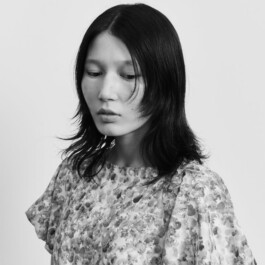 Black and white fashion portrait of model Ngawang Jinpa wearing a floral textured dress for the HERALBONY Spring 2026 campaign. 