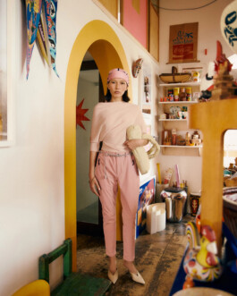 Fashion editorial image of model Ngawang Jinpa in a pastel pink outfit for Ginza Magazine x Columbia photographed in a colorful retro interior. 