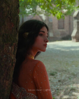 Deepika Sagar, ALF model, in a delicate orange embroidered outfit, leaning against a tree in the Bruhi Pant campaign 
