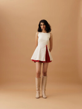Indian model Yashvi Birla wearing ivory sleeveless dress with red pleats and beige boots for Ose Studios lookbook 