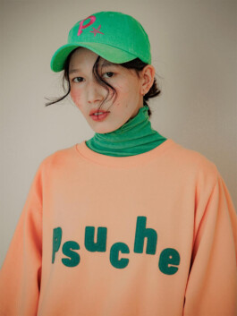 Ngawang Jinpa wearing a green cap and peach Psuche sweatshirt for ALF India modeling campaign 