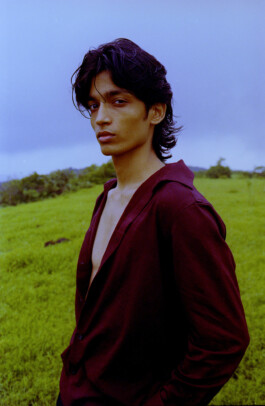 Aaditya Yadav, male model represented by A Little Fly (ALF India), editorial fashion shoot in open field wearing deep burgundy shirt 