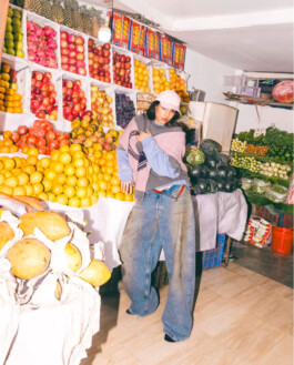Tania Shroff wearing Acne Studios with oversized jeans at a vibrant fruit and vegetable market in India, photographed by Tito for Ajio campaign 