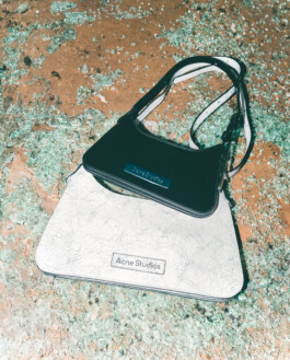 Close-up of two Acne Studios handbags from the Ajio collaboration placed on shattered glass, photographed by Tito for ALF 