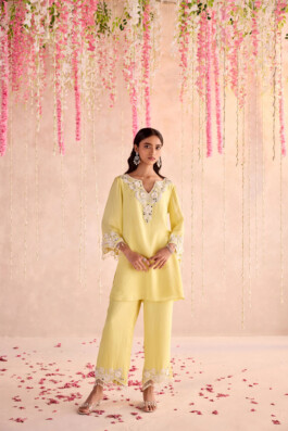 Dimple Aggarwal in a lemon yellow embroidered kurta and pants set for Seema Thukral, under floral pastel decor 