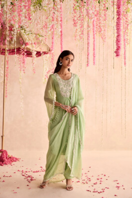 Dimple Aggarwal wearing a pistachio green embroidered kurta set for Seema Thukral’s lookbook, under cascading pink floral decor 