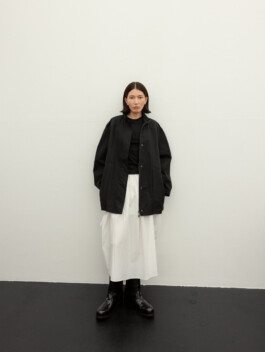 Ngawang Jinpa wearing black oversized jacket and white skirt with boots for Essential by EQL fashion editorial 