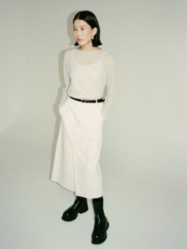 Model Ngawang Jinpa wearing a minimal beige dress with sheer black overlay for Essential by EQL fashion campaign 