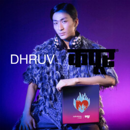 Nam Dorjee wearing feather-textured jacket and headphones, holding Dhruv Kapoor x boAt Nirvana box on purple background 
