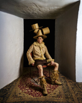 Nam Dorjee posing in an avant-garde outfit with sculptural headpiece, styled in a surreal editorial setting for ALF 