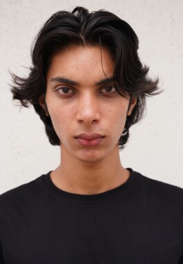 Front-facing colour digital of Indian male model Shammazul Anas with wavy black hair and clear brown eyes 