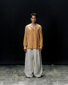 Siddharth Raghavan wearing a mustard yellow kurta-style shirt and wide white linen trousers for Puri fashion lookbook, represented by A Little Fly 