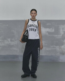 Ngawang Jinpa in Alfred SS25 lookbook wearing white sleeveless top with bold black lettering, navy wide-leg pants with side print, and black loafers, styled with Platinum Models Seoul for A Little Fly modeling agency India 
