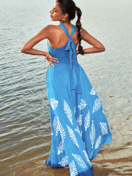 Shweta Poothery wearing a blue halter dress with white patterns by Elisamama, standing near the water 
