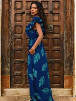 ALF model Shweta Poothery wearing a blue printed maxi dress with ruffled sleeves, posing against a carved wooden door for the Elisamama Campaign 