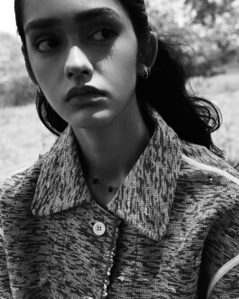 Black and white close-up portrait of model Theia Maeve wearing a textured jacket for the Maatii Studio campaign. 